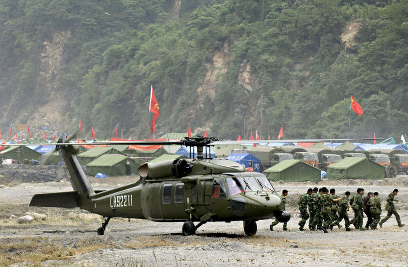 Chinese troops carry a survivor off a S-70 helicopter at a makeshift helipad in Yingxiu, southwest China’s Sichuan province on May 29, 2008.
